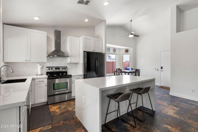 kitchen with black refrigerator, sink, a center island, wall chimney range hood, and electric stove