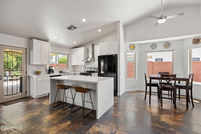 kitchen featuring white cabinets, black fridge, wall chimney exhaust hood, and stainless steel electric range oven