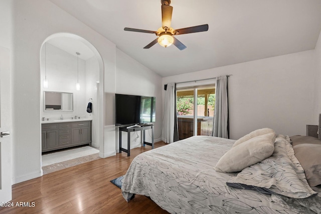 bedroom with lofted ceiling, connected bathroom, ceiling fan, and light wood-type flooring