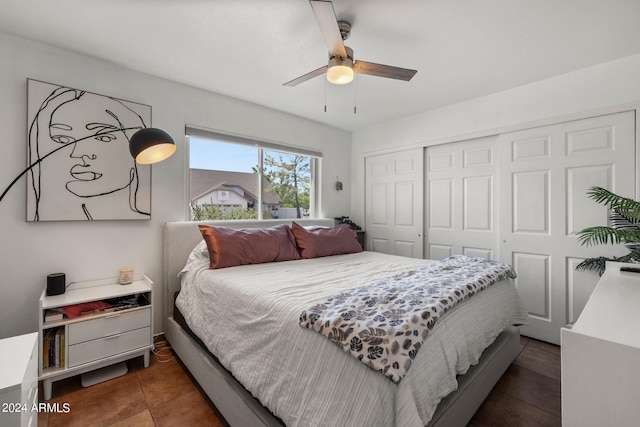 bedroom with dark tile patterned flooring, a closet, and ceiling fan