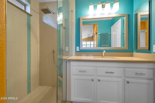 bathroom with tiled shower and vanity