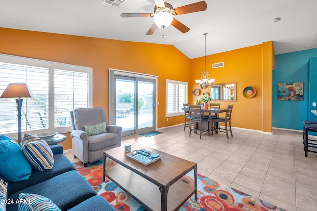 living room featuring ceiling fan with notable chandelier, light tile patterned flooring, and lofted ceiling