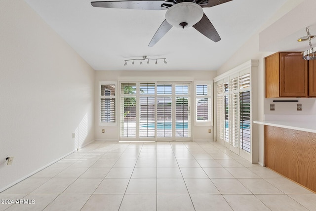 interior space with lofted ceiling, ceiling fan, light tile patterned floors, and rail lighting