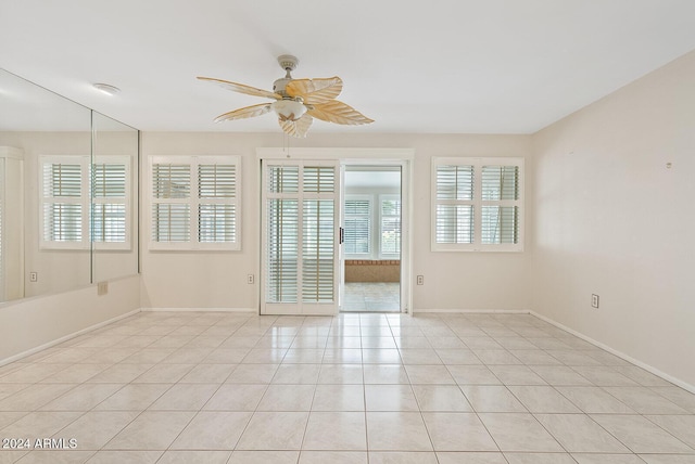 spare room with ceiling fan and light tile patterned floors