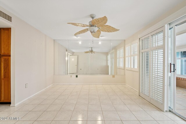 tiled spare room with ceiling fan