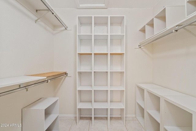 walk in closet with light tile patterned floors