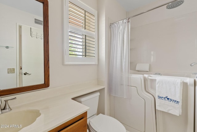 bathroom featuring a shower with shower curtain, vanity, and toilet