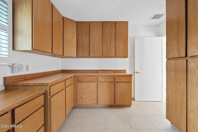 kitchen with butcher block counters and light tile patterned floors