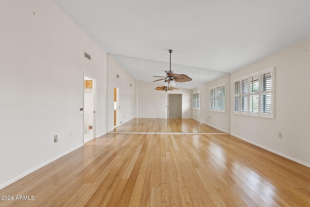 unfurnished living room with ceiling fan, light hardwood / wood-style floors, basketball court, and lofted ceiling