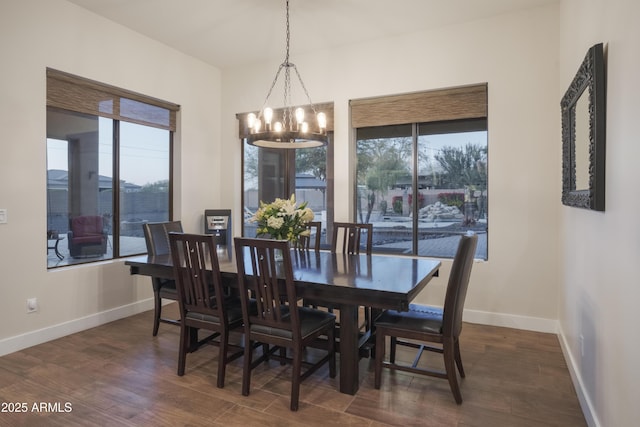 dining room with plenty of natural light, dark wood-type flooring, and a chandelier