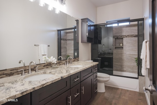 full bathroom featuring toilet, vanity, hardwood / wood-style floors, and combined bath / shower with glass door