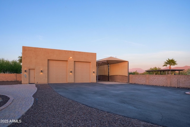 garage at dusk featuring a carport