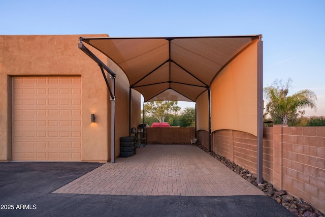 parking at dusk featuring a carport