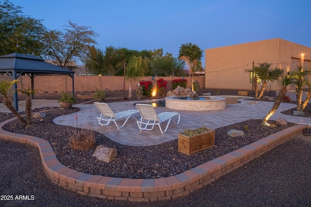 patio terrace at dusk featuring a gazebo