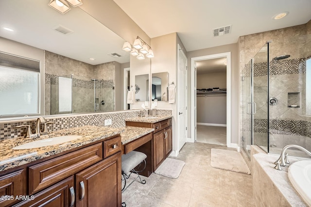 full bathroom with visible vents, backsplash, a spacious closet, a stall shower, and a sink