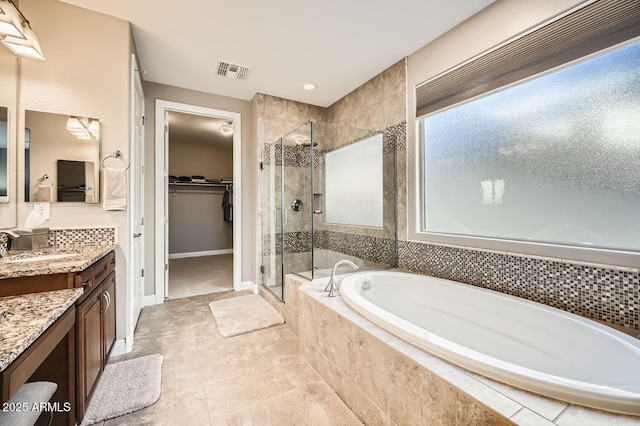 full bathroom featuring visible vents, a spacious closet, a shower stall, vanity, and a bath