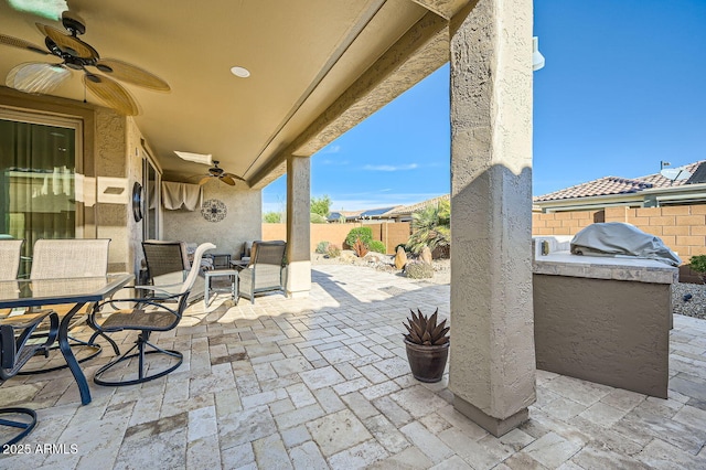 view of patio with a fenced backyard, outdoor dining area, a ceiling fan, and area for grilling