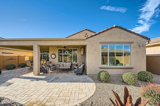 back of property featuring outdoor lounge area, fence, a ceiling fan, stucco siding, and a patio area