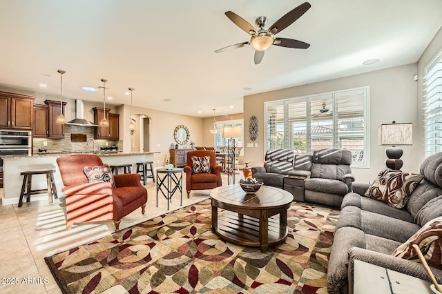 living area with light tile patterned floors, ceiling fan, arched walkways, and recessed lighting