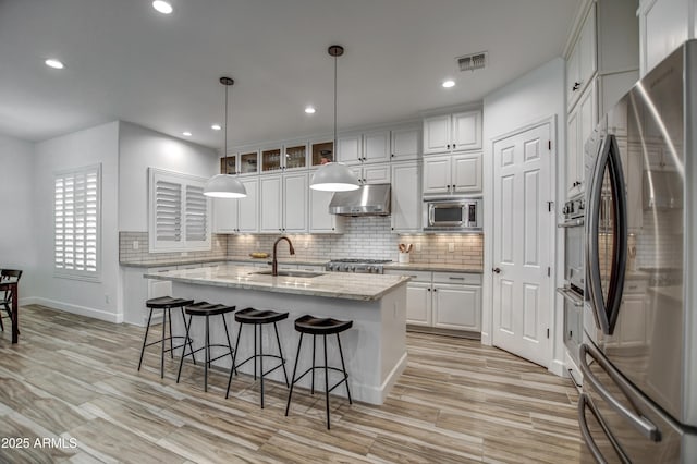 kitchen featuring white cabinetry, under cabinet range hood, and appliances with stainless steel finishes