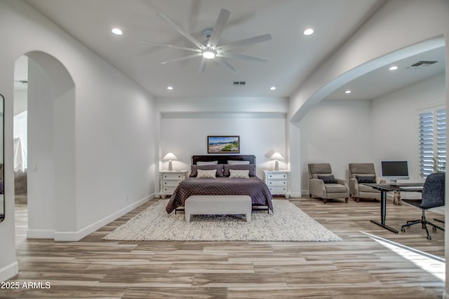 bedroom with recessed lighting, visible vents, light wood-style floors, and arched walkways