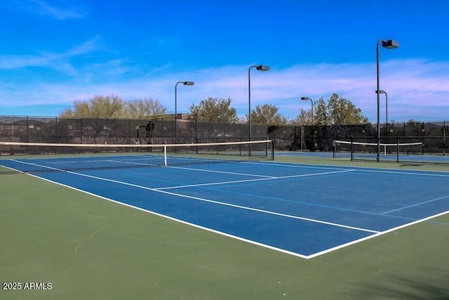 view of tennis court featuring fence