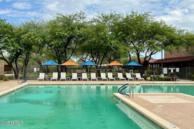 community pool featuring fence and a patio