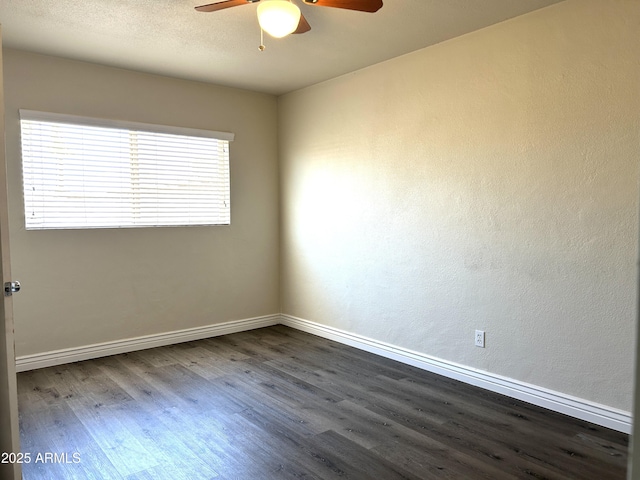 spare room featuring a textured ceiling, dark wood finished floors, a ceiling fan, and baseboards