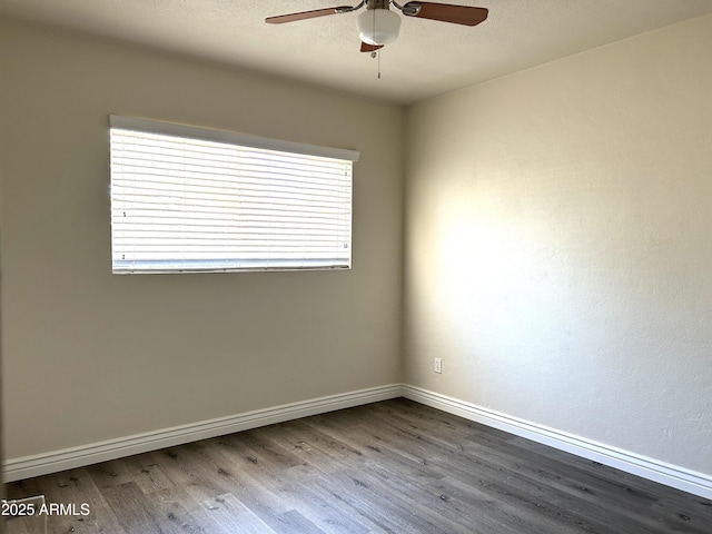 empty room featuring ceiling fan, wood finished floors, and baseboards