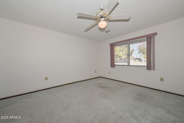 carpeted spare room with a ceiling fan, a textured ceiling, and baseboards