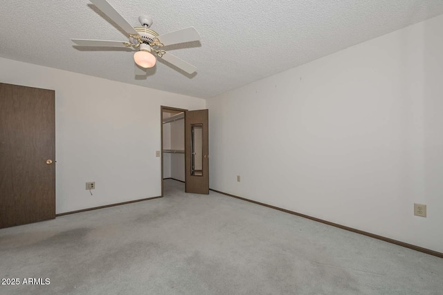 unfurnished room with light carpet, ceiling fan, a textured ceiling, and baseboards