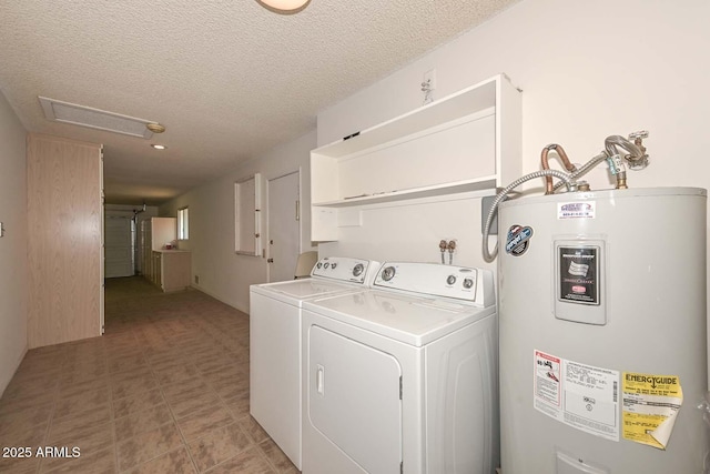 washroom featuring water heater, laundry area, a textured ceiling, and independent washer and dryer