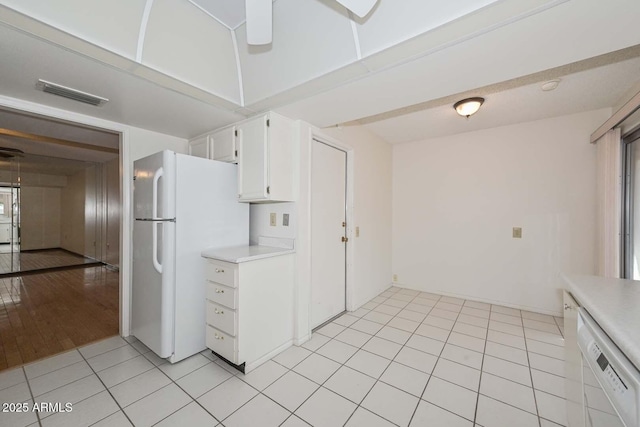 kitchen featuring white appliances, light countertops, visible vents, and white cabinets