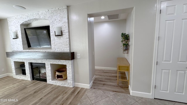 bathroom featuring a stone fireplace and hardwood / wood-style floors