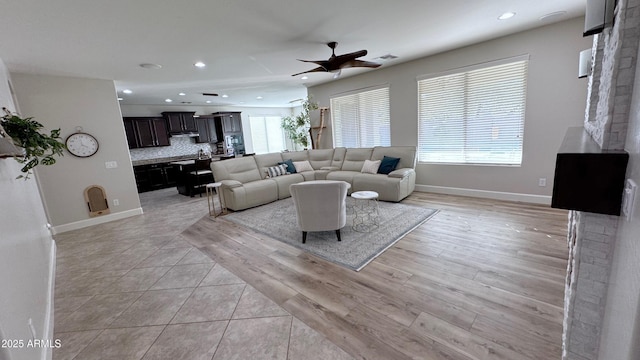 living room featuring ceiling fan and light hardwood / wood-style flooring