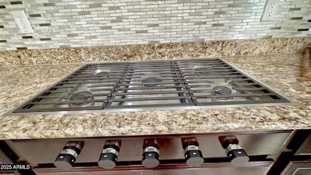 interior details with stainless steel gas stovetop and decorative backsplash