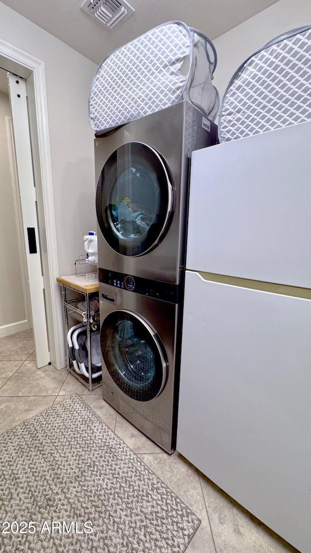 clothes washing area featuring stacked washer / dryer