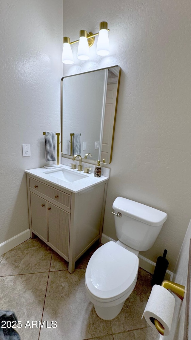 bathroom featuring vanity, tile patterned floors, and toilet