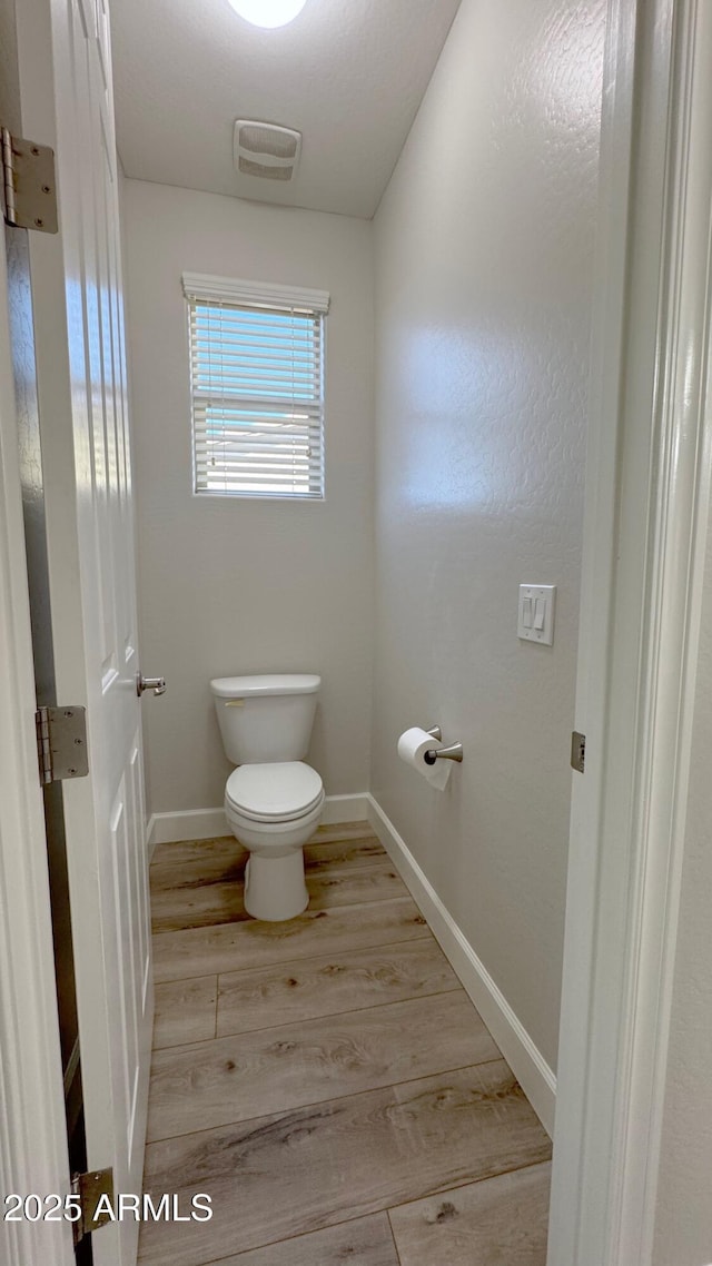 bathroom with wood-type flooring and toilet