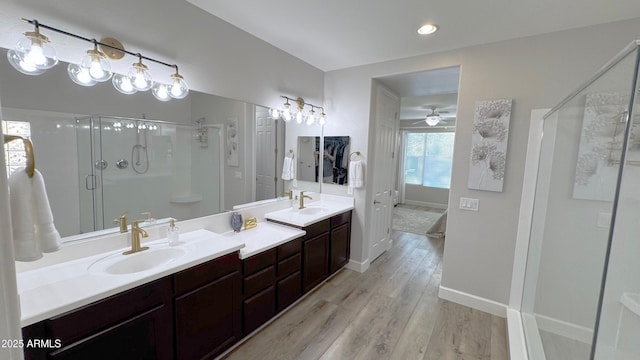 bathroom featuring walk in shower, ceiling fan, wood-type flooring, and vanity