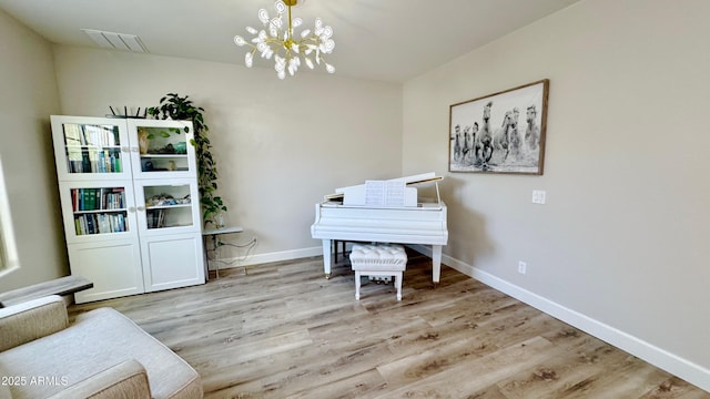 living area with a notable chandelier and light hardwood / wood-style flooring