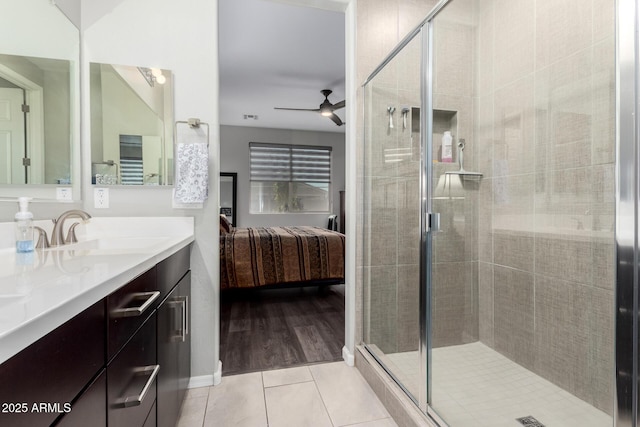 bathroom with ensuite bathroom, a stall shower, ceiling fan, vanity, and tile patterned floors