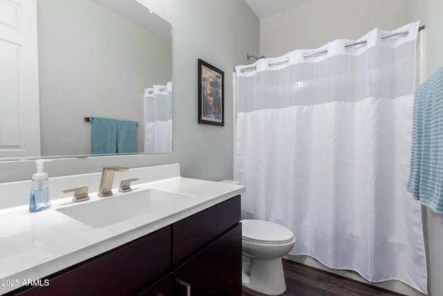 bathroom with toilet, wood finished floors, and vanity