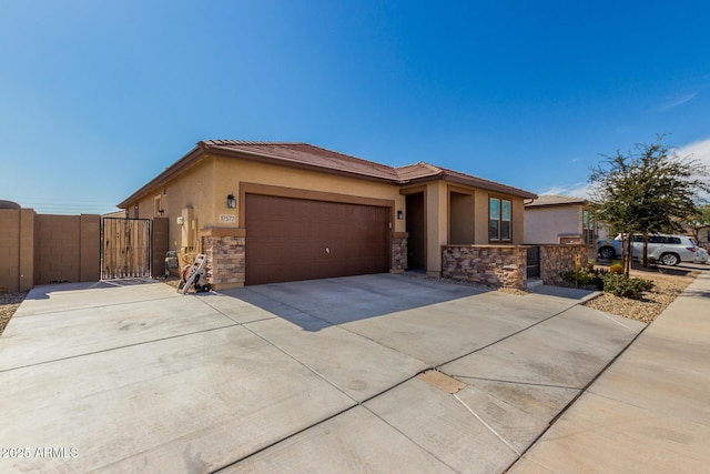 prairie-style home with a gate, stone siding, driveway, and stucco siding