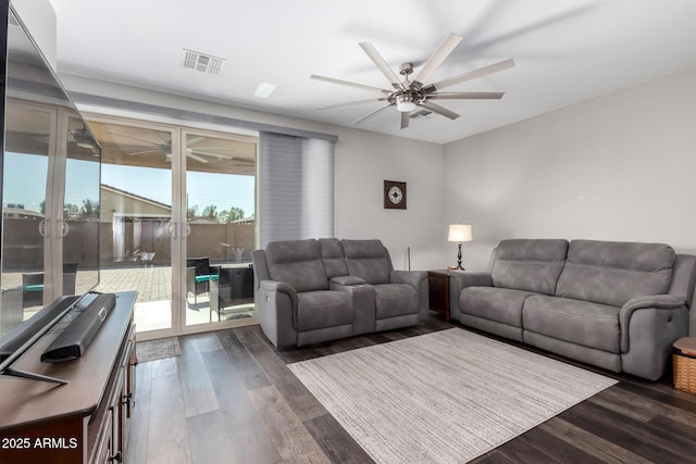 living area with dark wood-type flooring, visible vents, and a ceiling fan