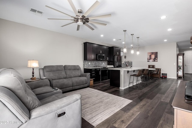 living room featuring visible vents, dark wood finished floors, baseboards, ceiling fan, and recessed lighting