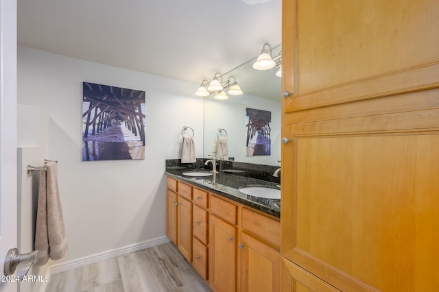 bathroom with wood-type flooring, vanity, and a chandelier