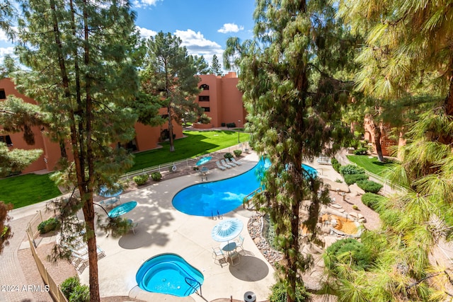 view of swimming pool featuring a lawn, a patio, and a hot tub