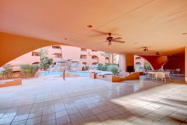 12212 N Paradise Village Pkwy S Unit 451, Phoenix, AZ 85032 - view of patio with a fireplace, ceiling fan, outdoor dining space, and a community pool