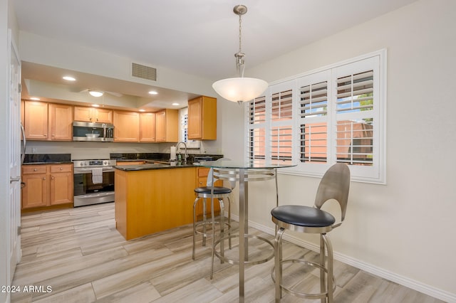 kitchen with kitchen peninsula, hanging light fixtures, light hardwood / wood-style flooring, stainless steel appliances, and light brown cabinets